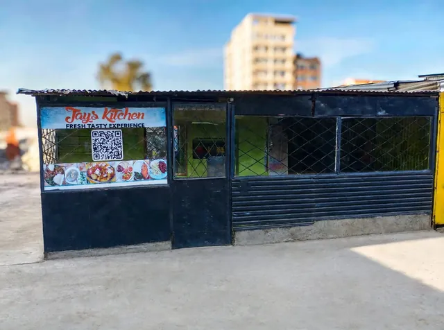 The front of Jays Kitchen: a black metal frontage with the Jays Kitchen sign, a QR code and food photos in the window